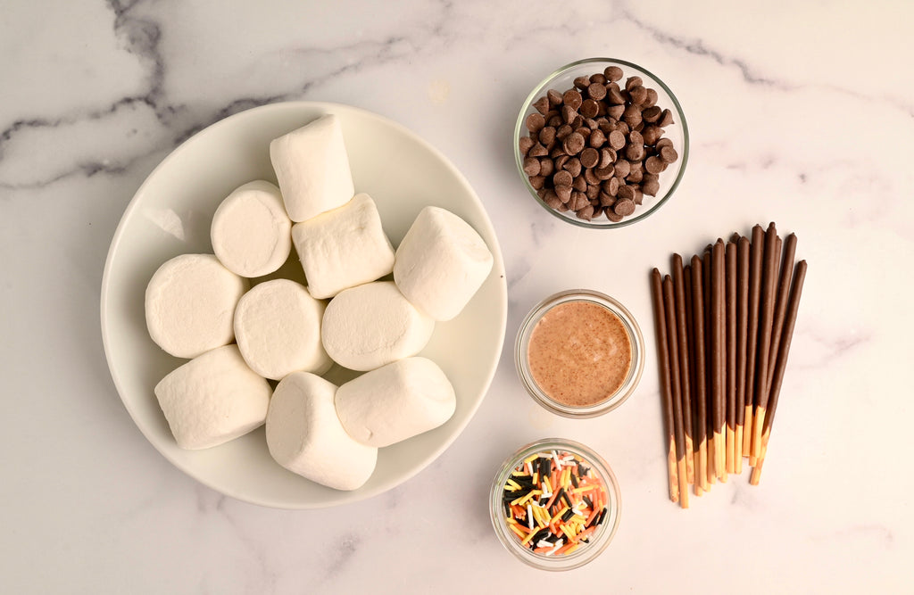 A white ceramic bowl of white fluffy marshmallows