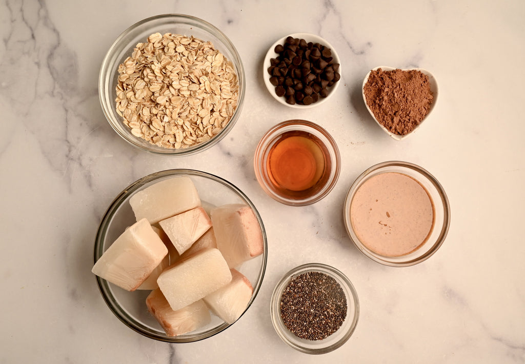 Raw oatmeal ingredients in clear glass bowls on a kitchen counter