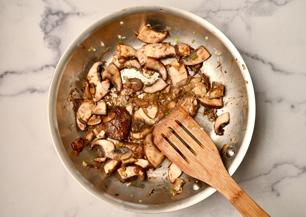 Mushrooms being mixed in a mixing bowl