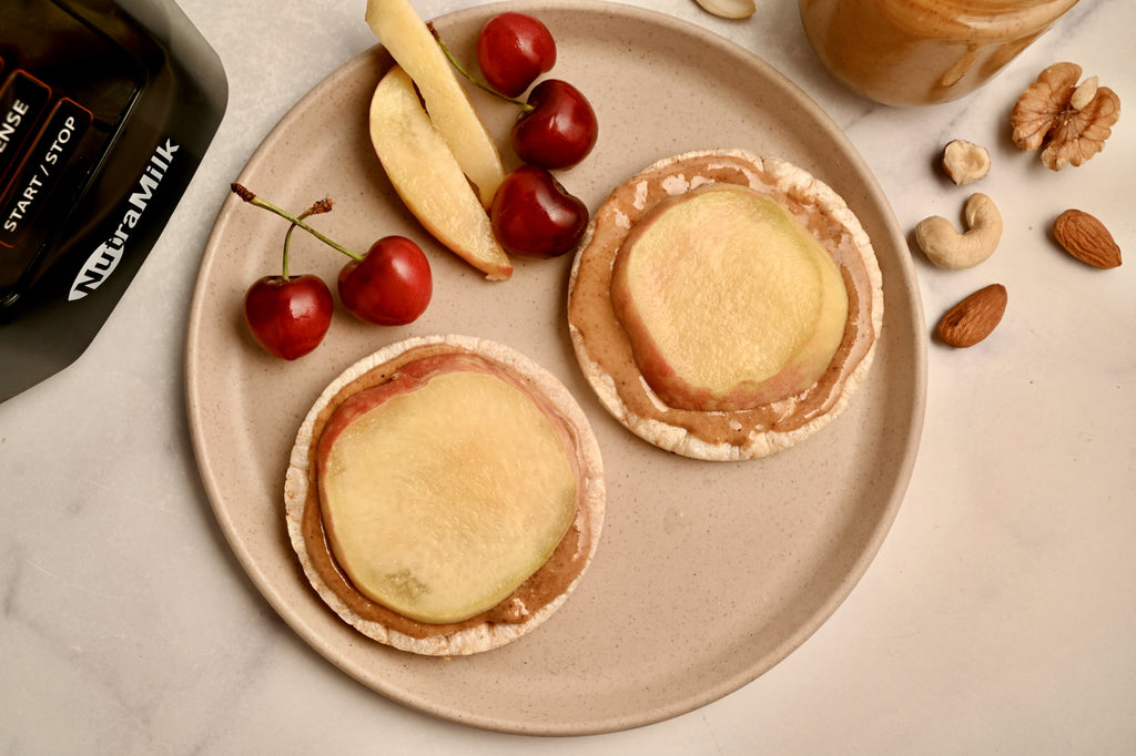 A plate with crackers and fruit and nut butter