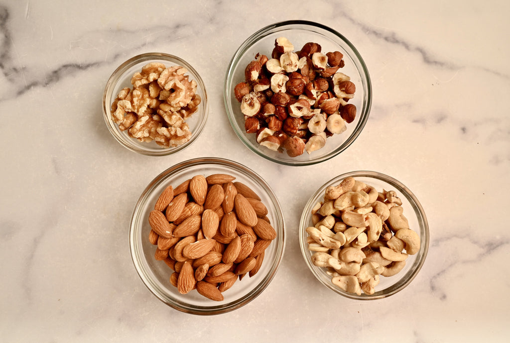 A kitchen counter with small bowls filled with raw nuts