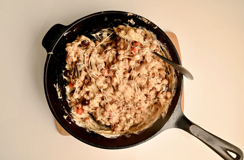 Cereal bar ingredients mixed up in a black cast iron skillet pan