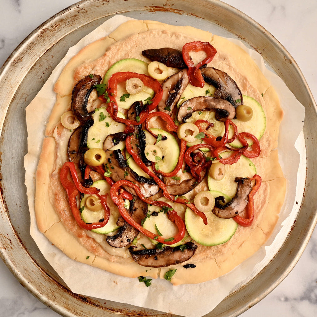 A close up of a Bianca pizza with veggies on top