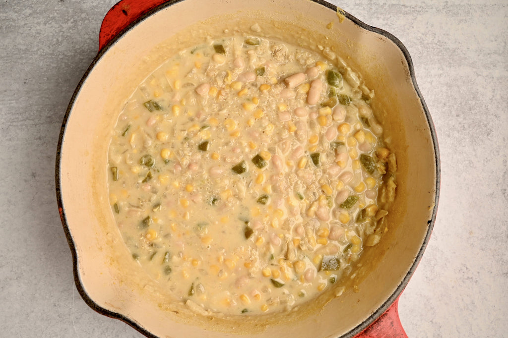 A close up of cooked white bean chili in a big bowl