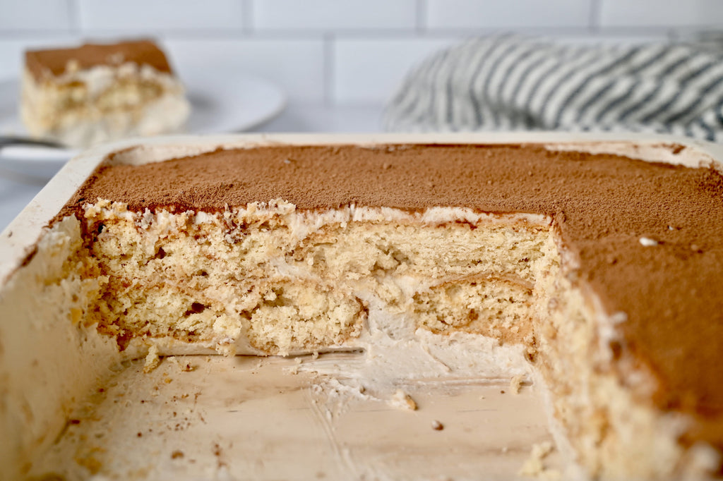 A tray of tiramisu cut into with slices taken out