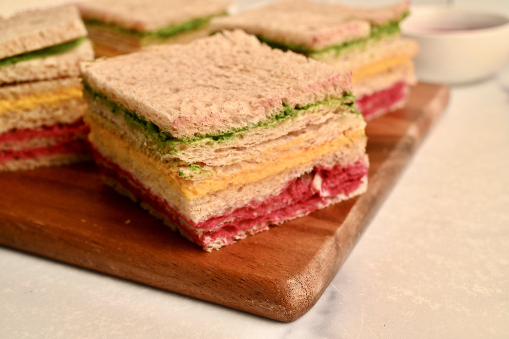A close up of a rainbow colored finger sandwich