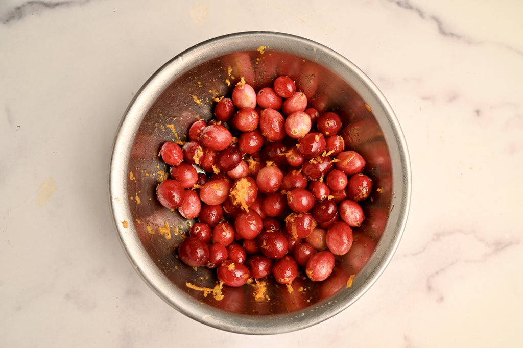 A bowl of raw cranberries mixed with orange zest