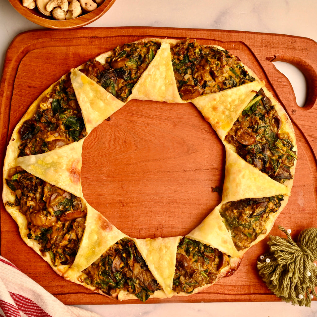 A close up of a mushroom and spinach pizza ring