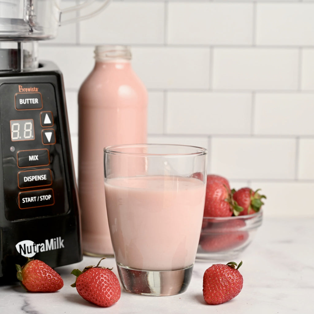 A clear glass filled with homemade strawberry oat milk