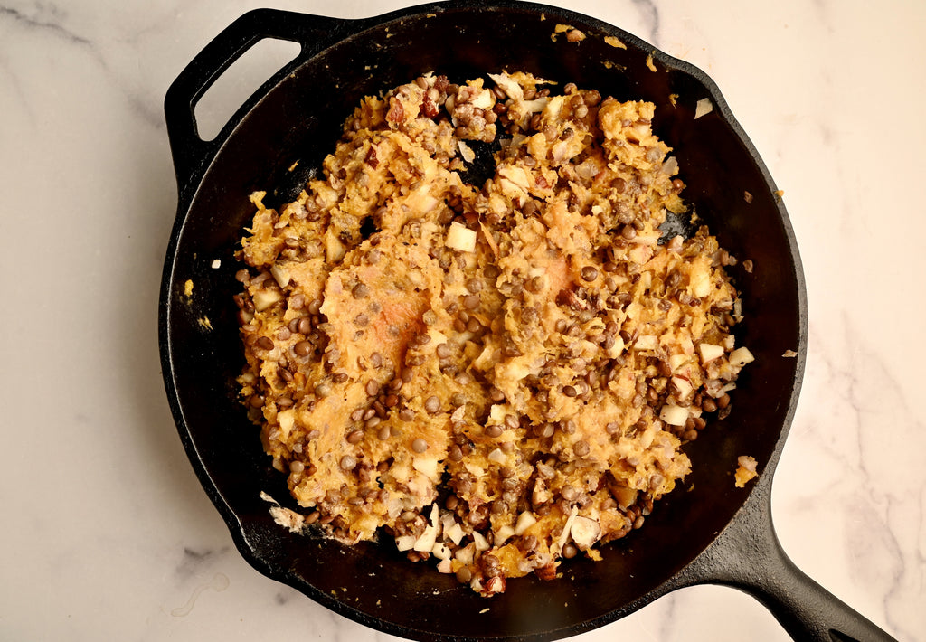 Cooked lentils and vegetables in a black cast iron skillet