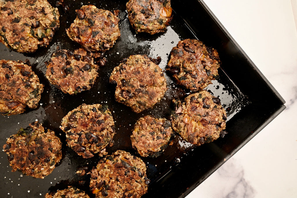 A close up of plant based burgers on a baking pan