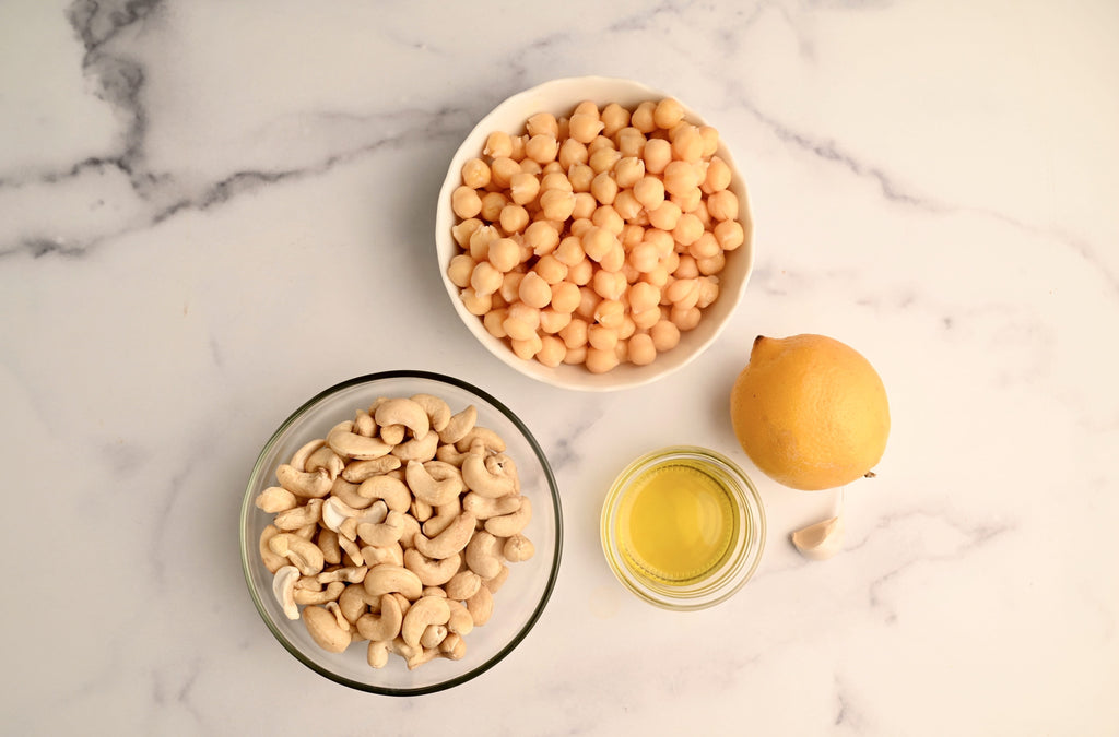 A clear glass bowl of raw cashews