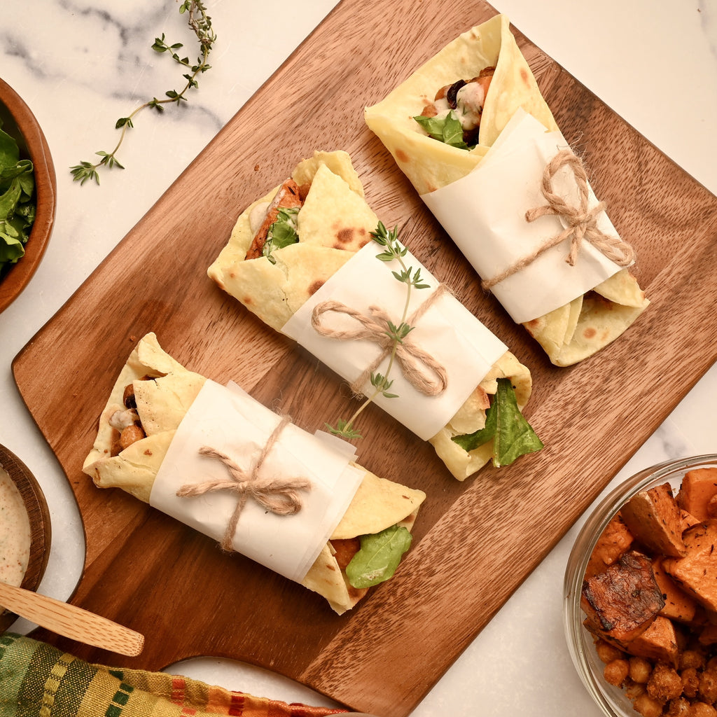 A close up of a turkey wrap on a wooden cutting board