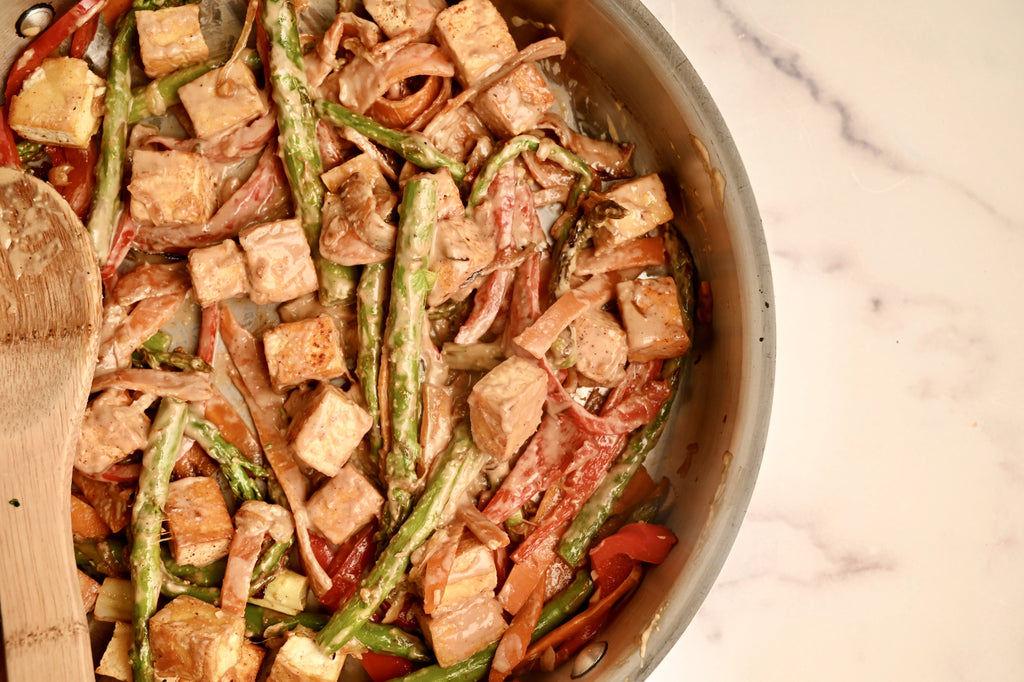 Tofu and vegetables simmering in a peanut sauce
