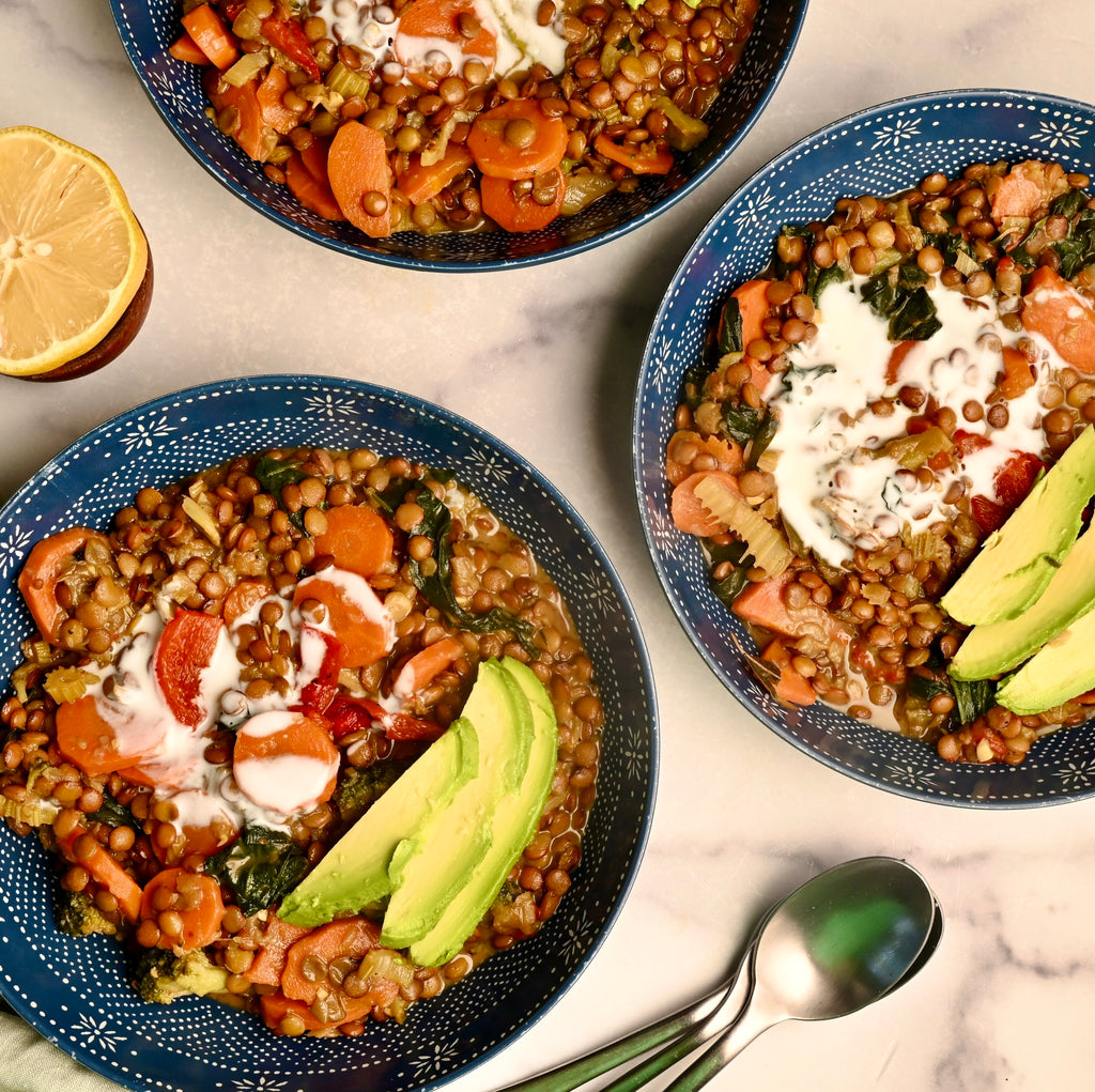 Two blue bowls filled with lentil and vegetable soup