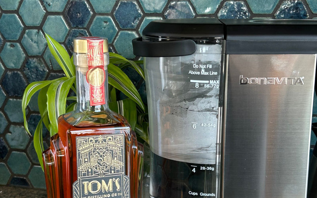 Enthusiast Coffee Brewer sits alongside a bottle of spirits.