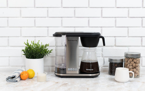 The Enthusiast Coffee Brewer sits atop an ultra modern marble kitchen countertop.