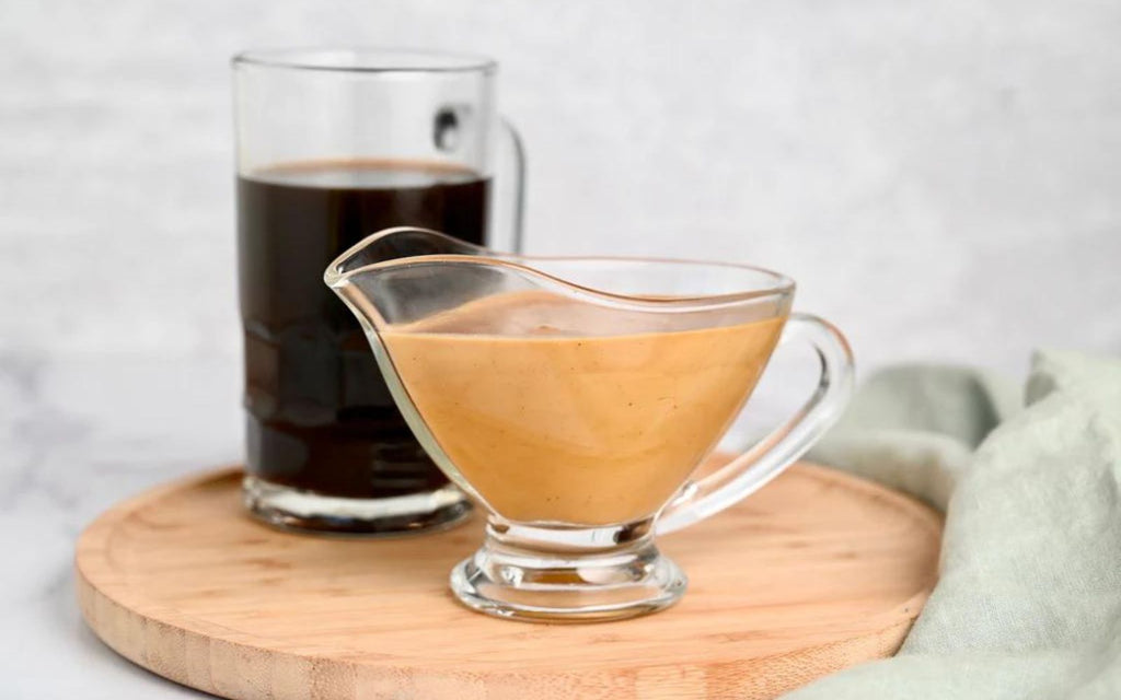 A cup of coffee and a glass of plant-based milk are sitting on a countertop.