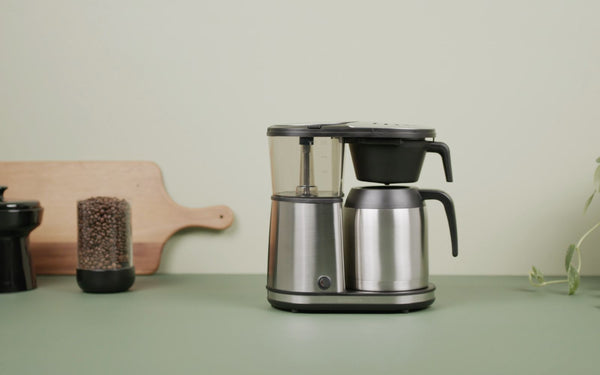 The Connoisseur coffee brewer sits on a green countertop.