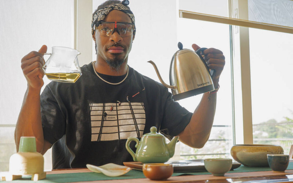 Taurean Nixon is holding a Bonavita kettle and Brewista glass server while going through his tea ritual.