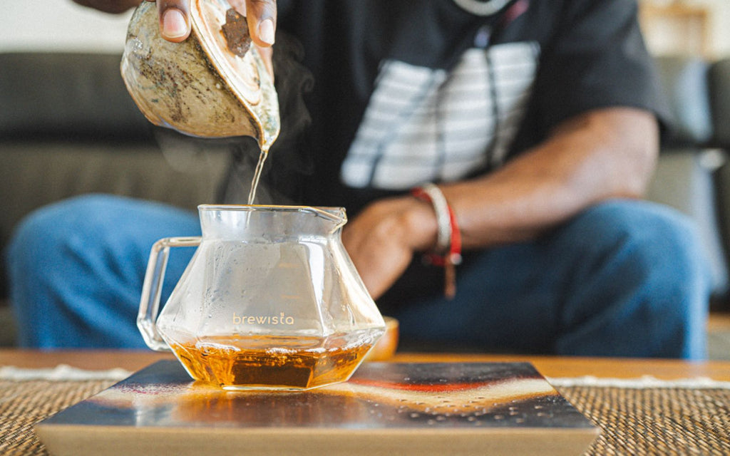 Taurean Nixon pours tea into a Brewista X Series Glass Server.