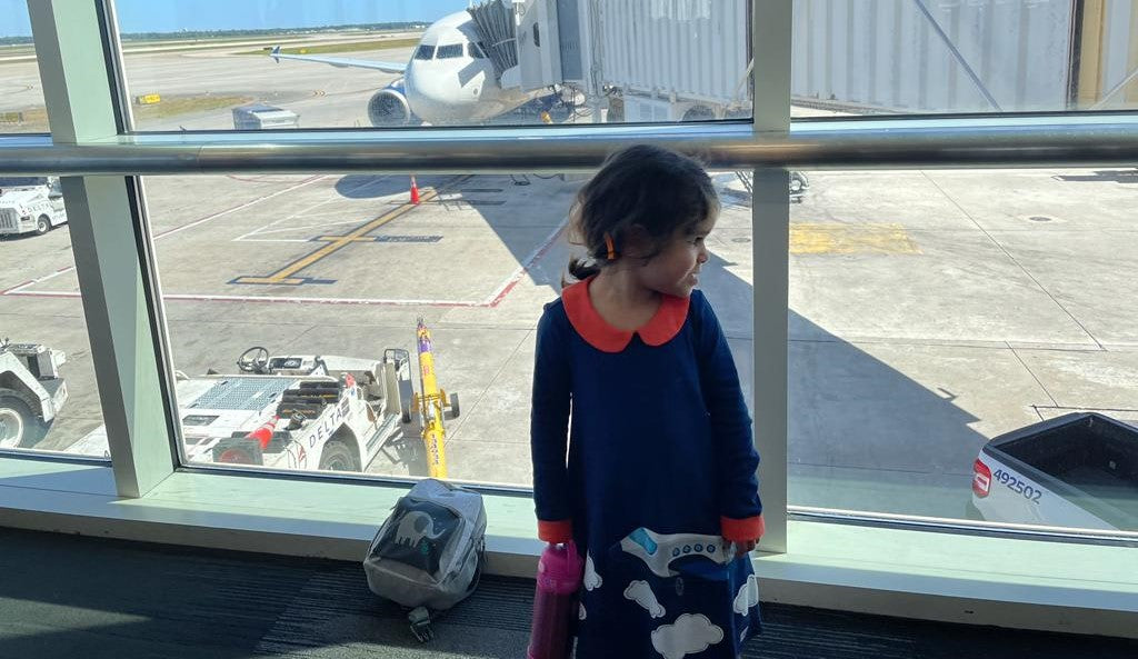 Girl wearing an Airplane dress by prisma kiddos at the airport