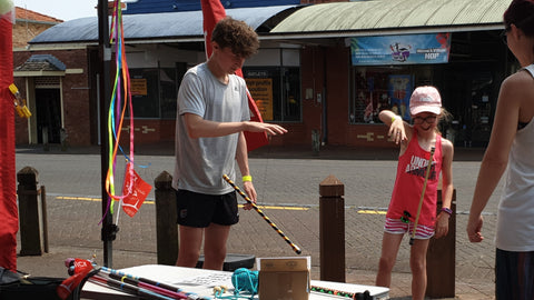 Two children play with levi wand at a market stall
