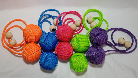 Five sets of brightly coloured monkey fist poi sit on a white backdrop