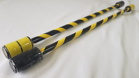 A set of black and yellow iso sticks / mini double staff sit against a white background