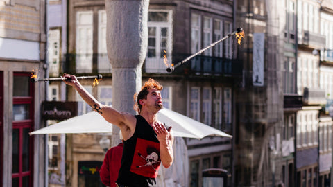 A street performer juggles with double fire staff