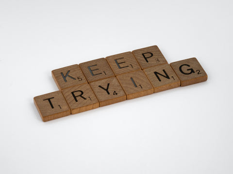 Wooden scrabble letters spell out 'keep trying'