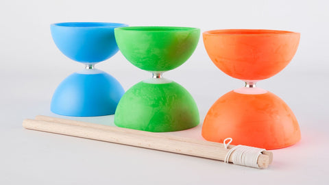 Three brightly coloured diabolo sit on a light coloured backdrop