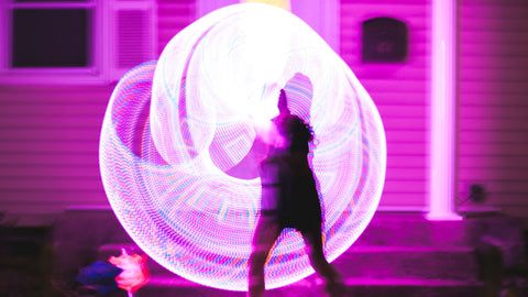 A blurred image of someone spinning an LED hula hoop with a light trail effect
