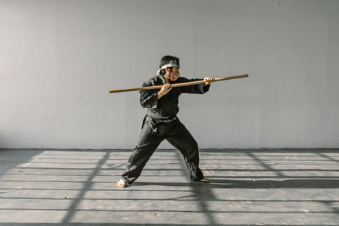 A martial arts practitioner is mid way through swinging a spin staff