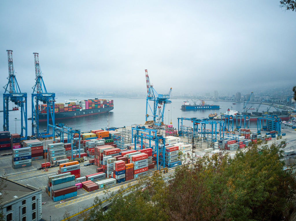 Aerial view of a port and loading docks with shipping containers.