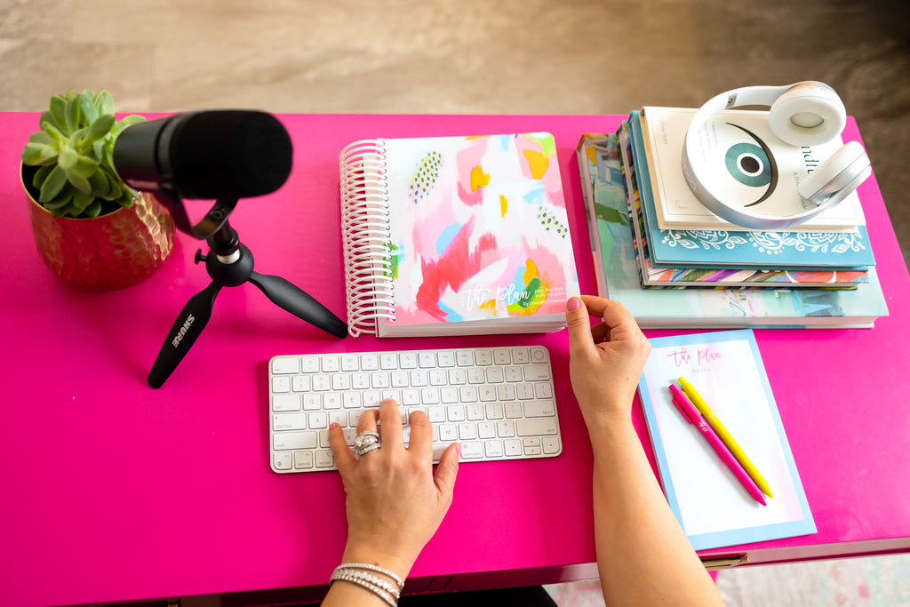 Photo of podcast materials on pink desk