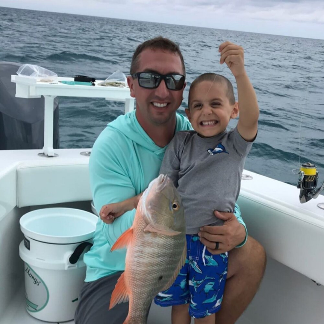 Man and boy holding fish