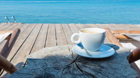 Wooden floor and sea view with chaise longues and coffee