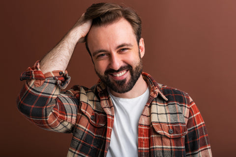Portrait of goodlooking attractive stylish bearded man on brown background