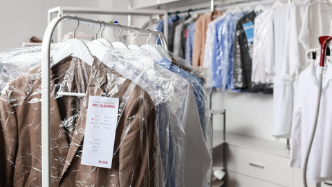 clothing on racks in dry cleaning bags
