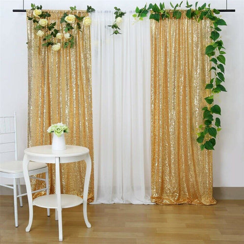 Gold And Withe Sequin Wedding Backdrop Curtain With Artificial Plant Behind A White Table