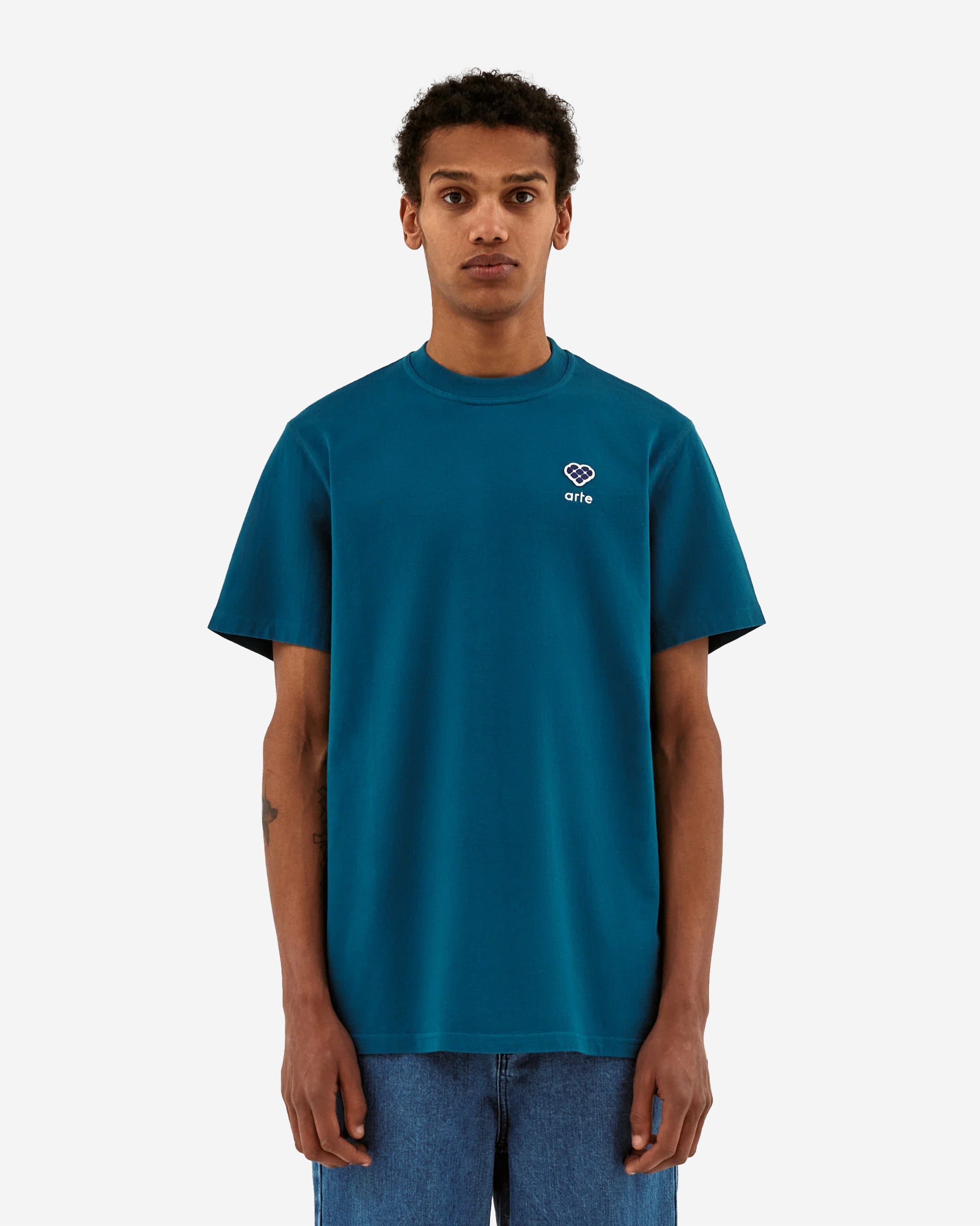 The Tommy Heart Patch T-shirt is a perfect base T-shirt for your wardrobe. The blue T-shirt is made out of premium cotton, cut in a relaxed regular fit and has a slightly higher neck. On the left chest a seasonal Arte logo patch with a white embroidery below.