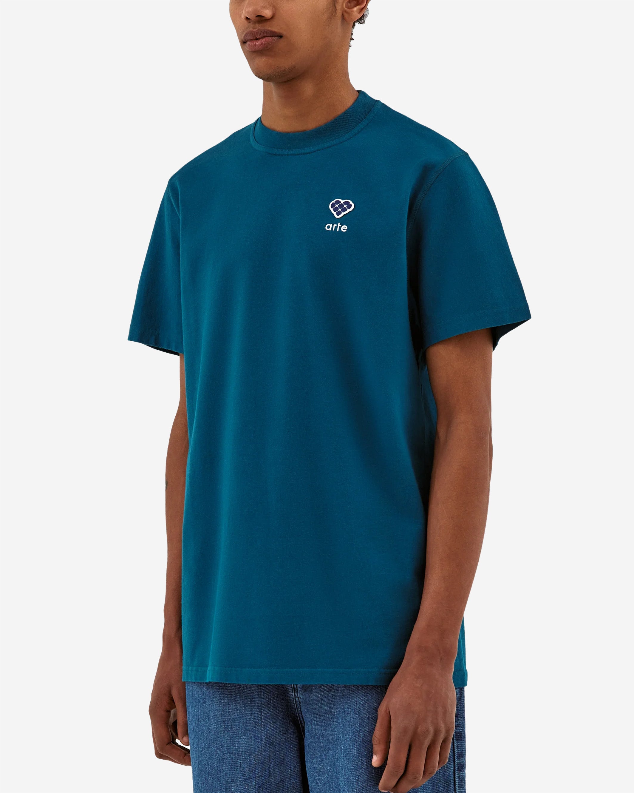 The Tommy Heart Patch T-shirt is a perfect base T-shirt for your wardrobe. The blue T-shirt is made out of premium cotton, cut in a relaxed regular fit and has a slightly higher neck. On the left chest a seasonal Arte logo patch with a white embroidery below.