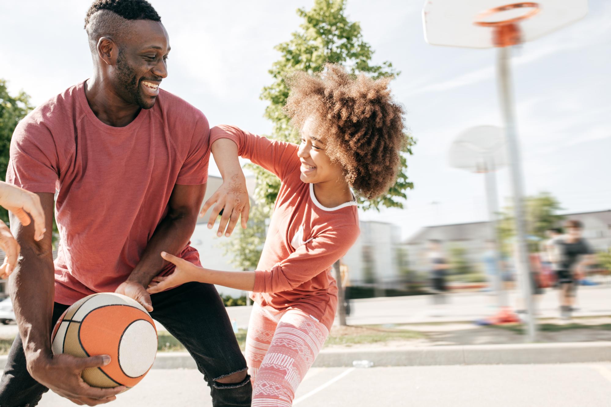 Dad playing basketball with daughter