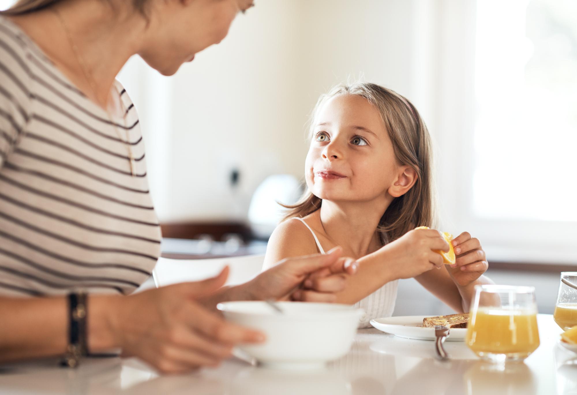 girl having breakfast with her mother at home