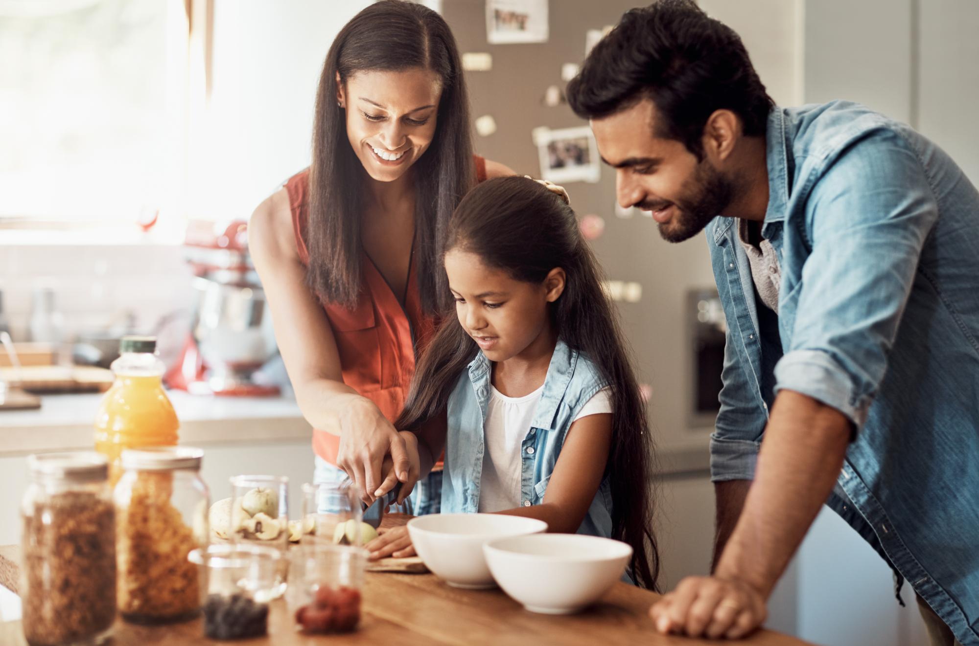 Shot of a happy young family preparing a meal in the kitchen together at home