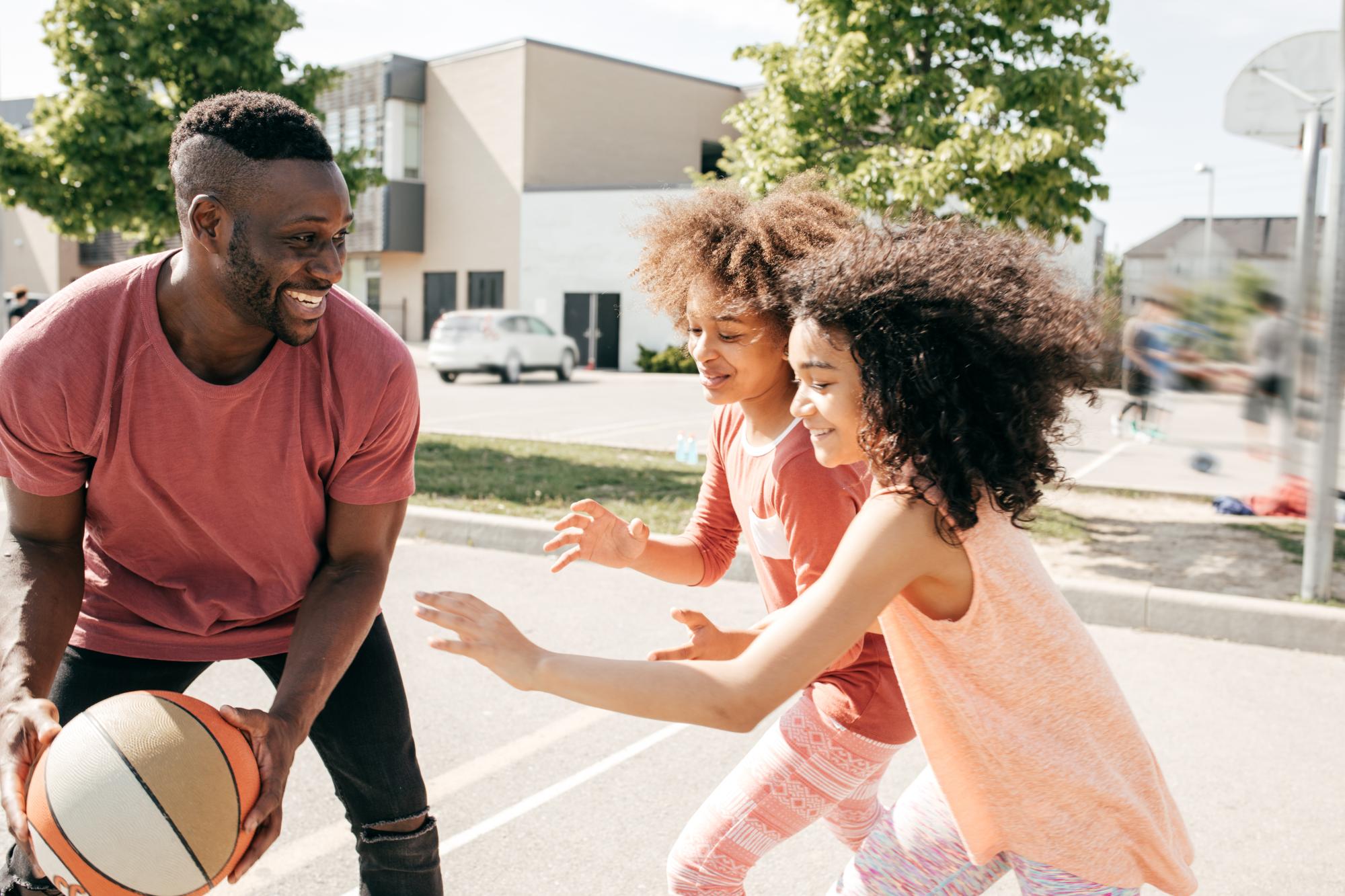 Father playing basketball with kids