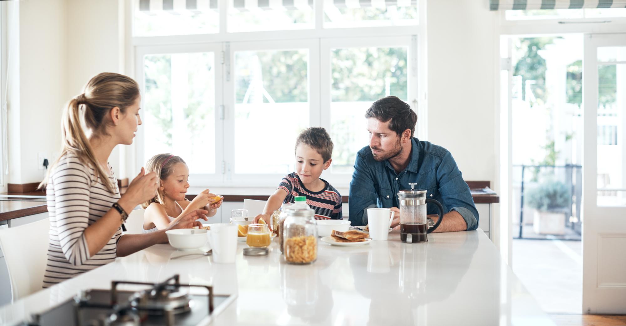 happy family of four having breakfast