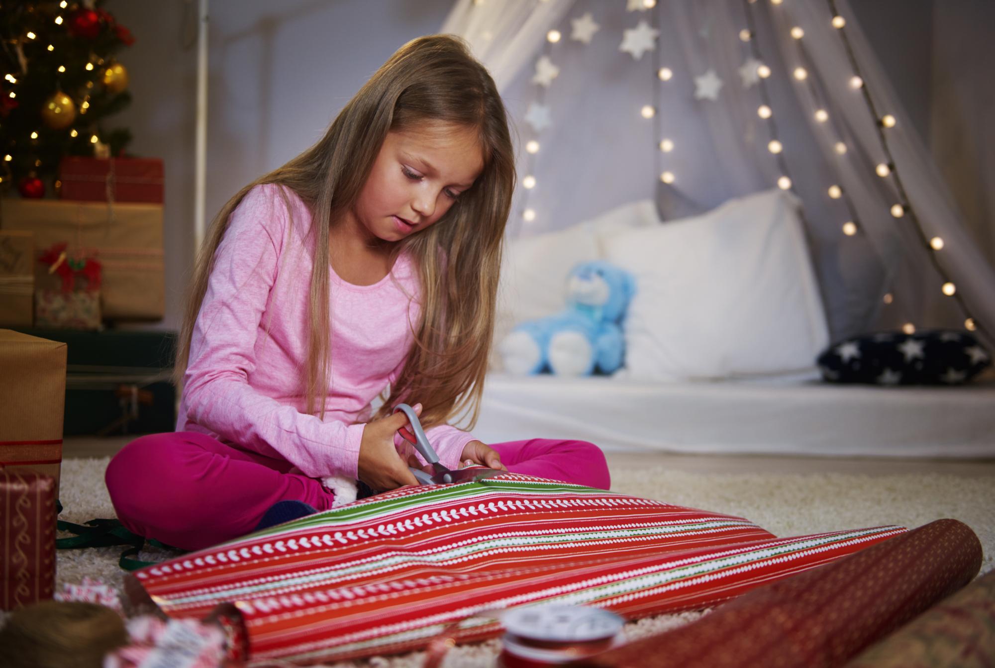 girl cutting christmas paper