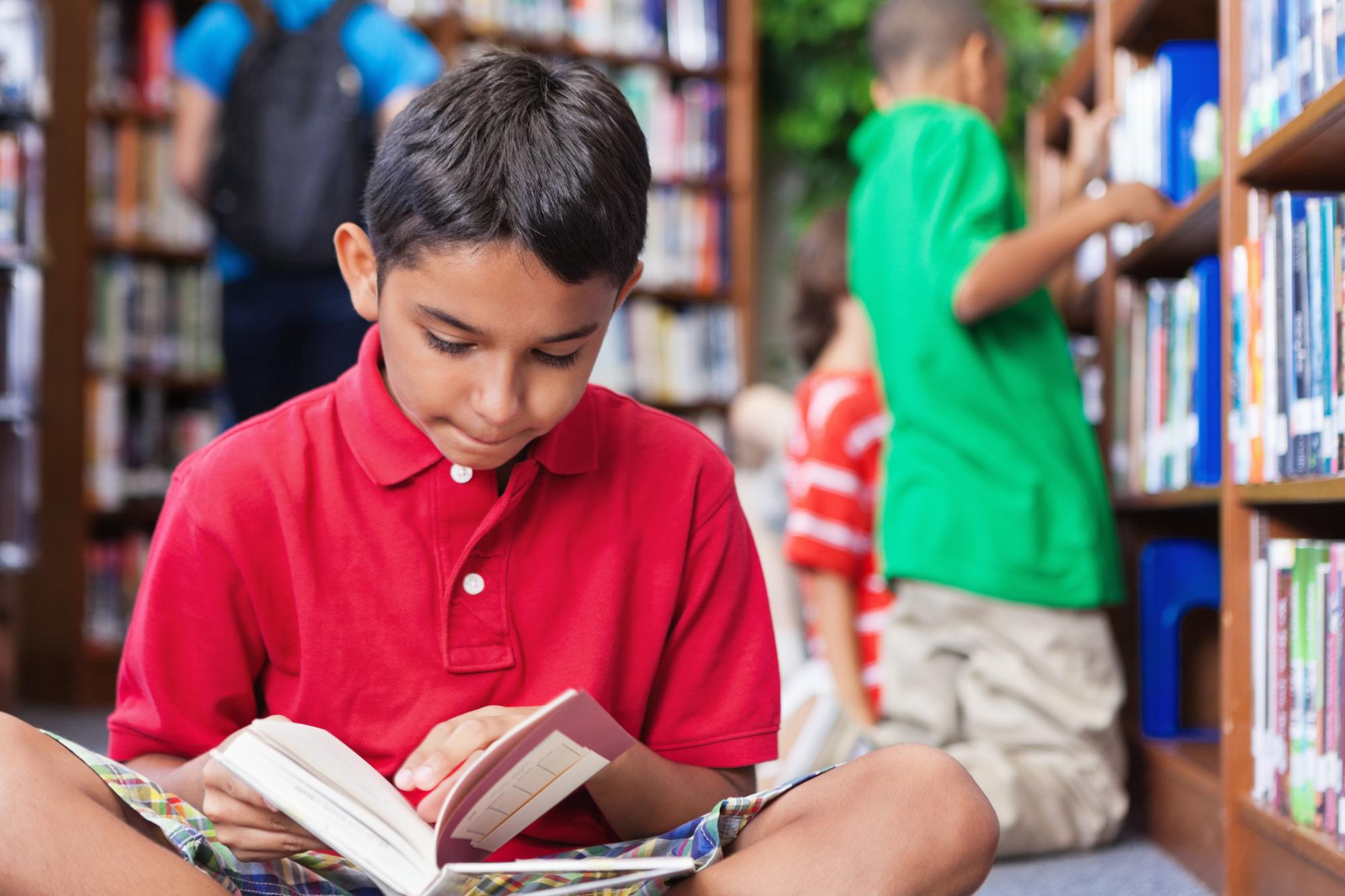 student reading a book in school library